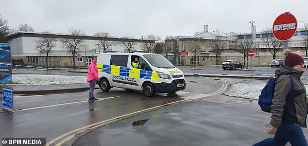 The victim is said to have been sitting in a car when the knifeman lashed out stabbing her in the leisure centre car park. Pictured: Police at the scene on Friday morning